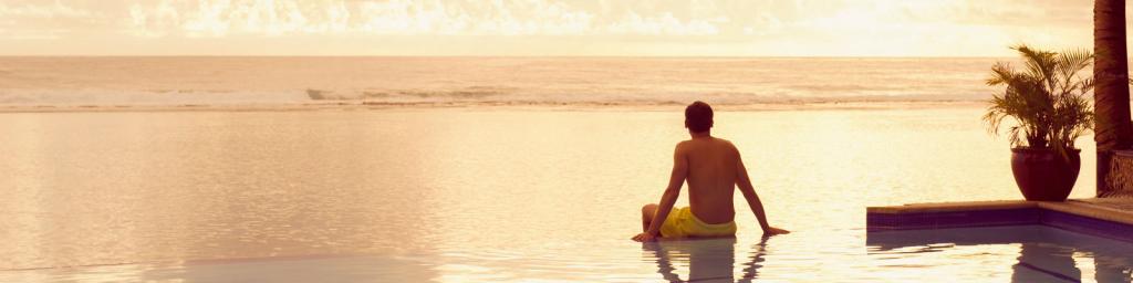 Travel Associates man sitting on infinity pool at dusk rarotonga