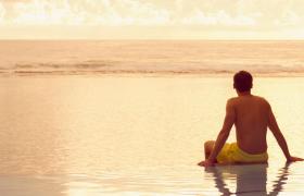 Travel Associates man sitting on infinity pool at dusk rarotonga